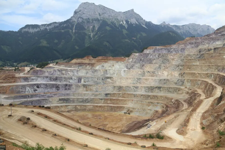 Terraced open-pit mine below a mountain